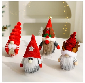 Detail of four handmade Christmas gnomes with knitted hats and plush reindeer antlers