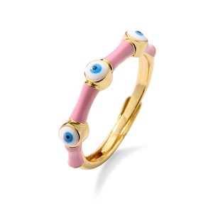 Detailed shot of gold open ring with pink enamel finish and blue evil eye charms