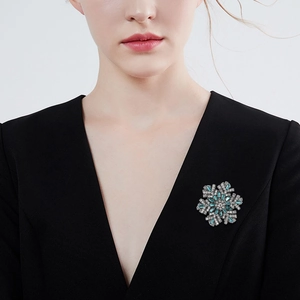 Sparkling snowflake brooch with blue crystals on black suit lapel for elegant women