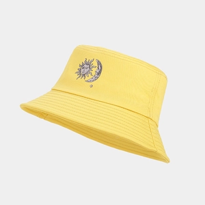 Dettaglio cappello alla pescatora giallo con ricamo sole e luna e cuciture rifinite con cura