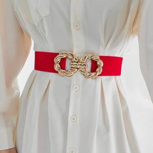 Detail of red elastic waist belt featuring a stylish gold double-ring metal buckle on model