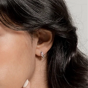 Close-up of S925 sterling silver figure-eight hoop earrings with twisted texture on model