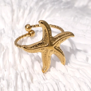 Gold starfish open ring with hammer texture finish on white coral background