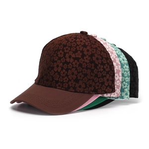 Detail view of floral baseball caps in brown, pink, green, and black stacked options