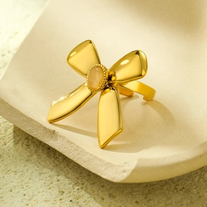 Elegant gold bow-knot ring with a yellow oval gemstone on a minimalist stone base
