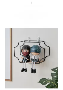 Detail view of wave-shaped black iron wall shelf with wooden base and decorative ornaments