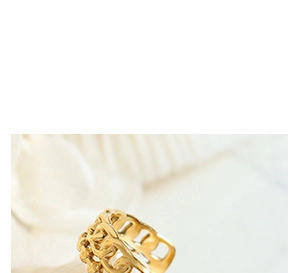 Gros plan sur une bague dorée ajourée et tissée aux détails métalliques vintage complexes