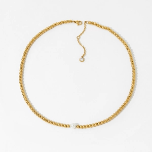 Minimalist gold beaded pearl necklace with a sparkling diamond pendant on white background