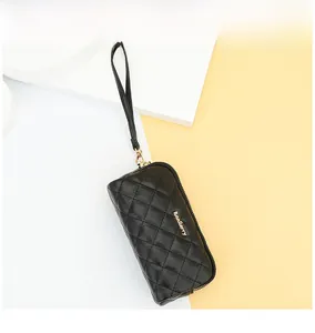 Detailed view of black quilted long wallet with double zipper and wrist strap