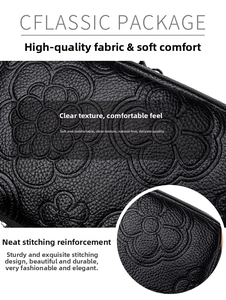 Gros plan du motif de camélia gaufré sur sac en cuir noir avec détails de couture précis