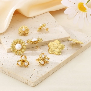 Detailed close-up of vintage flower stud earrings with pearls on a stone base