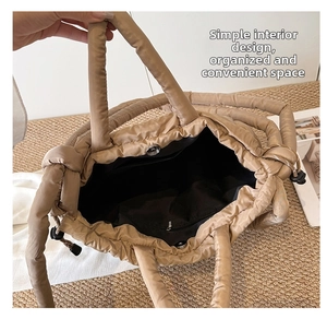 Detailed interior of khaki quilted tote bag showing magnetic closure and zipper pocket