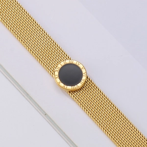 Detail of 18k gold mesh watch band bracelet featuring black Roman numeral center piece
