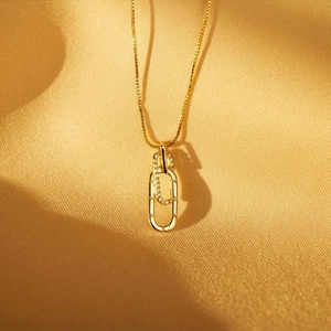 Detail of gold interlocking rings necklace with Forever engraving and pavé crystals