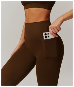 Detail shot of yoga leggings showing the side pocket holding a smartphone securely