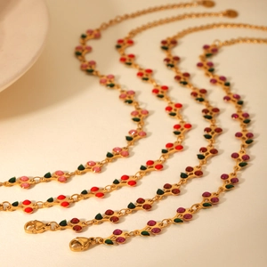 Detail of 18K gold plated stainless steel cherry bracelets in pink, red, and purple enamel