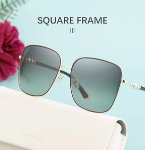 Detailansicht der quadratischen Sonnenbrille mit goldenen Bügeln und weißem Brillenetui