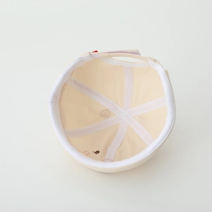 Detail of internal reinforced stitching and adjustable strap on cream baby docker hat