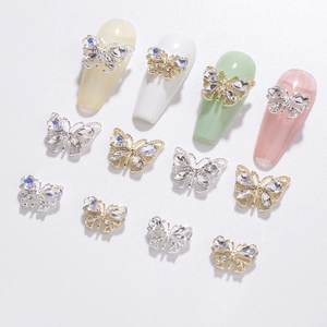 Macro shot of 3D hollow butterfly nail charms with zircons in gold and silver finish