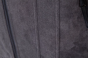 Detail of dark grey faux suede fabric with black zippers and precision stitching