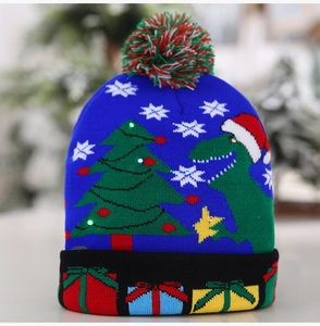 Détail du bonnet de Noël bleu tricoté avec LED, motif dinosaure festif et pompon doux