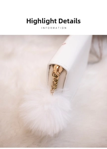 Detailed close-up of a golden zipper with a white faux fur pompom on a luxury wallet