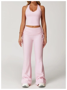 Detailed side view of pink halter crop top and high-waisted flared yoga leggings