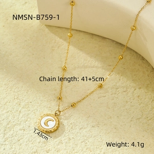 Macro shot of 18K gold moon pendant with beaded chain on stone texture background