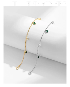 Detail of silver and gold bead bracelets featuring green gemstones and white zircons