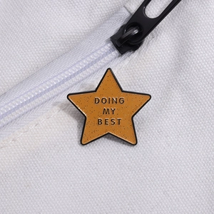 Minimalist yellow star enamel badge with 'DOING MY BEST' text on white canvas background