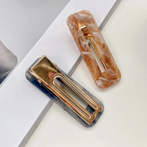 Rectangular acrylic hair clips in amber and grey tortoise shell patterns with gold metal