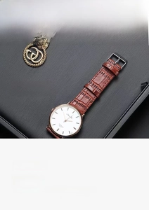 Macro detail of black brushed PU leather jewelry tray with watch and necklace