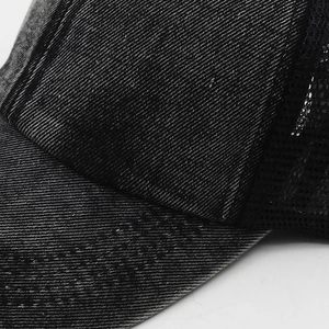 Close-up of the washed denim fabric and breathable black mesh on the baseball cap
