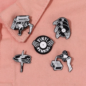 Vue détaillée de pins vintage en émail noir et blanc sur fond de jean rose fuchsia