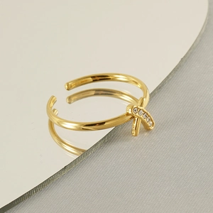 Macro detail of 18k gold plated stainless steel X-shaped ring with small crystals