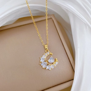 Detailed close-up of crescent moon pendant with heart zircon on a beige jewelry box