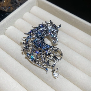 Close-up of silver hollow horse head brooch with sparkling blue and purple rhinestones