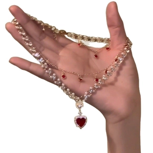 Collier doré à trois rangs avec pendentif cœur rouge et détails en zircone