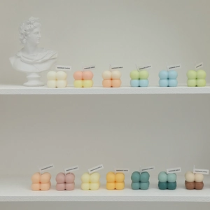 Minimalist bubble cube candles in pastel colors on a shelf for Nordic home decor