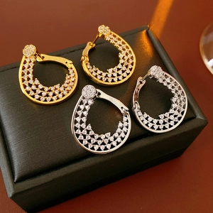 Close-up of gold and silver flower ear buckles with cubic zirconia on black leather