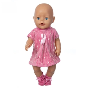 Close-up of baby doll in pink polka dot dress with matching socks and bow detail