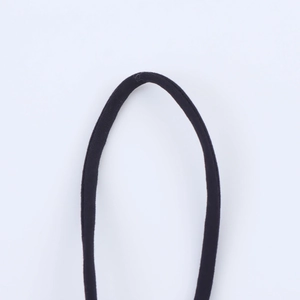 Détail d'une bretelle en tissu noir tissé avec une texture raffinée pour robe