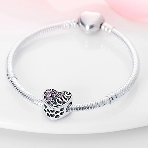 Detail of silver snake chain bracelet with heart charm featuring Love text and pink crystals