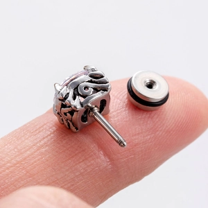 Gros plan d'un clou d'oreille vintage en acier pour homme avec zircon sur un doigt