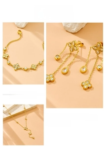 Detail view of gold clover jewelry set with sparkling crystals and tassel chains