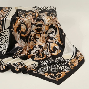 Close-up of baroque pattern on large silk satin scarf with gold floral scroll details