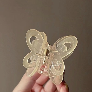 Macro shot of a transparent butterfly hair claw clip with visible metal spring detail