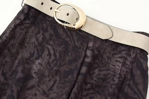 Detalle de falda midi vintage con estampado de leopardo y cinturón con hebilla dorada