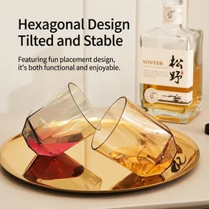 Minimalist hexagonal tilting glass tumbler with amber gradient on a golden tray