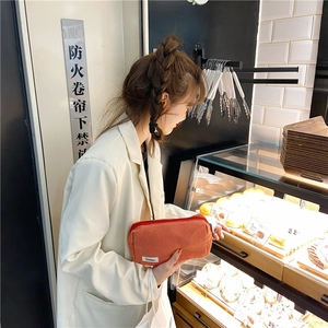 Mannequin tenant une trousse de maquillage en toile à carreaux orange avec zip
